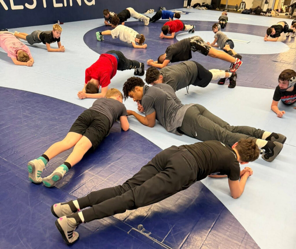 Chestnut Hill Wrestling Club Students engaging in a high intensity Planking workout to prepare themselves for the days Wrestling Lesson