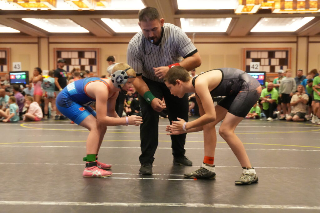 Students of Chestnut Hill Wrestling Club Preparing to engage in a Wrestling Match watched by A ref