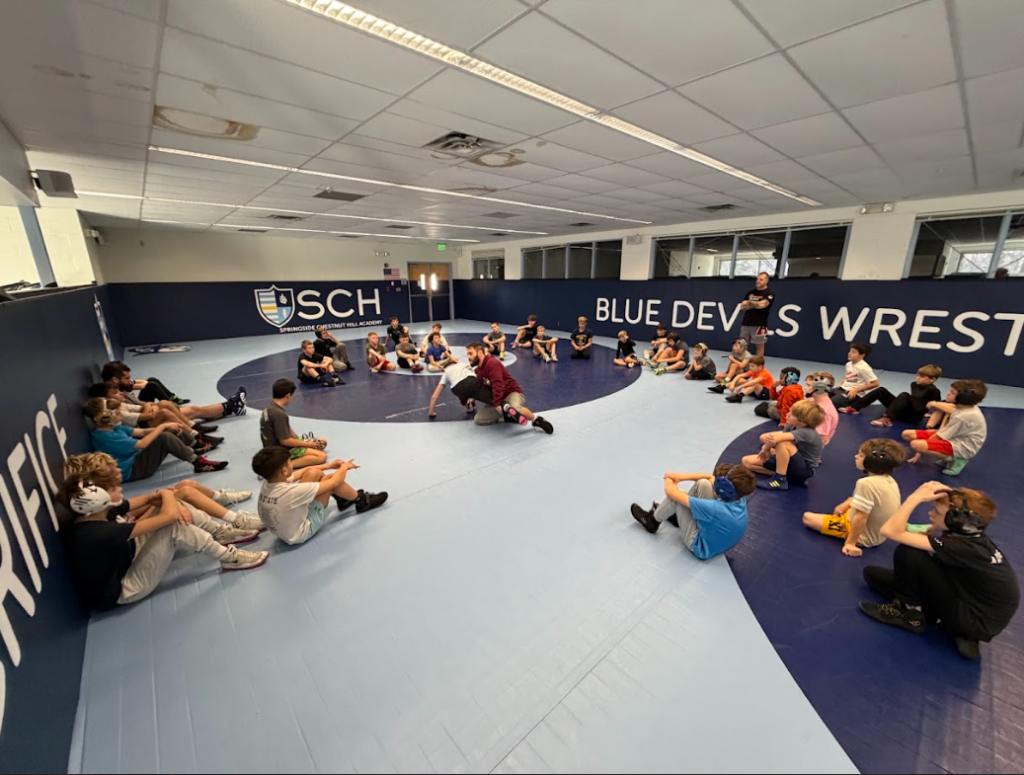Chestnut Hill Wrestling Club Students watching a demonstration by Josh Kindig while Jeff Moretti Spectates